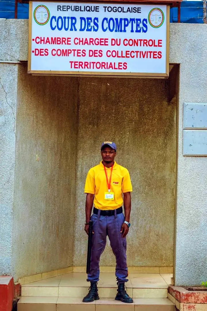 Agent Fox en faction à l'entrée d'une institution à Lomé